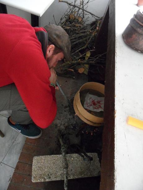 Giulio Garzisi soffia sulla brace per l'essiccazione degli stimmi. Lavorazione dimostrativa, non destinata alla produzione