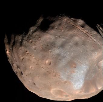 Un nuovo modello suggerisce che le scanalature che attraversano la luna di Marte Phobos siano state prodotte dall’attrazione gravitazionale reciproca fra il pianeta e il suo satellite. Crediti: NASA / JPL-Caltech / Università dell’Arizona.