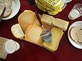 Several cheeses with a slicer, bread and milk.JPG