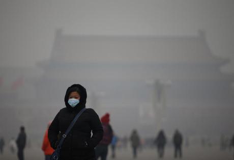 A woman wearing a mask makes her way during a polluted day at Tiananmen Square in Beijing January 15, 2015. Beijing issued its first smog alert of 2015 on Tuesday. Stagnant and humid air has aggravated the city's air pollution, causing the smog to linger, according to Xinhua News Agency. REUTERS/Kim Kyung-Hoon (CHINA - Tags: ENVIRONMENT)