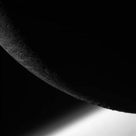 La sonda Cassini della NASA durante l'ultimo passaggio ravvicinato con Encelado: nella foto (scattata con la narrow-angle camera) una zona poco illuminata della luna ghiacciata, con il pianeta Saturno sullo sfondo. La foto è stata scattata da una distanza di circa 24.000 chilometri (146 metri per pixel). Crediti: NASA/JPL-Caltech/Space Science Institute