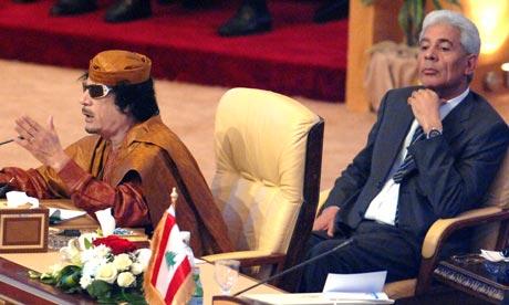 Moussa Koussa sits behind Muammar Gaddafi, the Libyan Ruler, at an Arab League summit in 2009