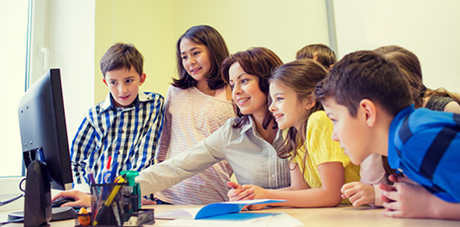 Maestra e bambini di fronte a un computer