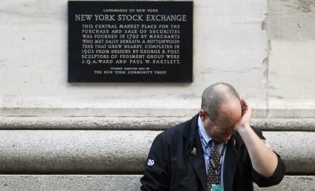 A weary trader rubs his eyes as he pauses outside the New York Stock Exchange following the end of the trading session in New York October 9, 2008. The Dow Jones Industrial Average dropped 678.91 points on the day to finish at 8579.19 closing below 9,0...