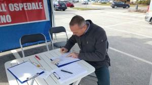 Un signore ad un gazebo del Comitato a sostegno dell'Ospedale di Luino