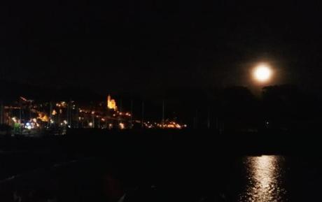 Cervo alla luce della luna piena, vista dalla vicina San Bartolomeo al Mare. Si nota la chiesa dei Corallini illuminata