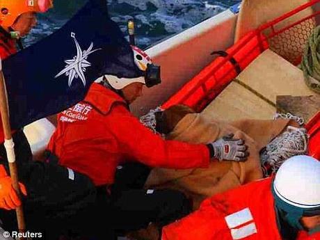 Safe and hound: A member of the Japan Coast Guard comforts the dog that seems to have survived an amazing three weeks at sea following the devastating tsunami