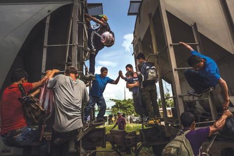 Migranti irregolari aiutano un ragazzino a passare tra i vagoni del treno merci noto come 