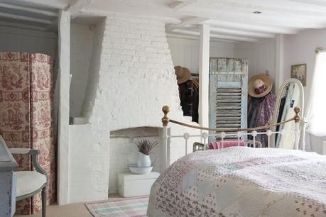 Un romantico cottage nel Surrey The bricks of a disused fireplace in an upstairs bedroom have been painted white to reflect the light – and avoid the gloominess associated with low, beamed ceilings. A Victorian-style bed is draped with a lovely handmade spread from Love Lane Vintage
