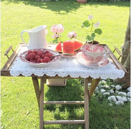 Un romantico cottage L'immagine può contenere: persone sedute, tabella, fiore, pianta, erba, spazio all'aperto e cibo