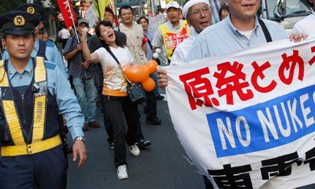 I manifestanti passano la sede della Tepco, l'operatore della centrale nucleare di Fukushima Daiichi