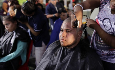 FOTO DEL GIORNO 22 AGOSTO 2011 : SI RASANO I CAPELLI IN SOLIDARIETà  AL LORO  PRESIDENTE CHAVEZ AFFETTO DA UN CANCRO