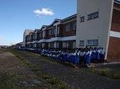 bambini davanti all'ingresso della nuova scuola