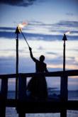 Guerriero accende le lanterne per la sera a Malolo island Resort