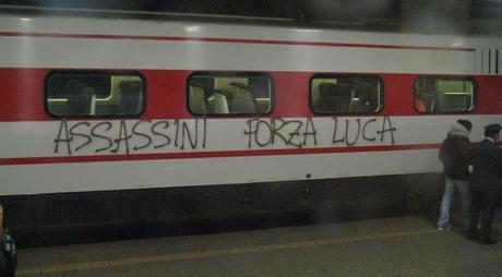 Un treno fermo nella stazione di Genova Principe, fotografato da un altro treno sul binario a fianco. Sulla fiancata del treno si legge 