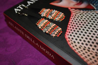 A FASHION BOOK, A REFLEX AND A PAIR OF EARRINGS